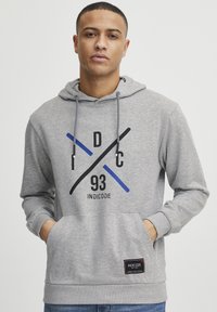 Gray hoodie with a front pocket, featuring black, blue, and gray graphic elements and a stitched logo label at the hem. Drawstring hood.