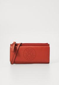 Rote Leder-Clutch mit abnehmbarem Trageriemen, ausgestattet mit geprägtem Logo-Rundmotiv und einem Reißverschluss oben. Glatte Textur.