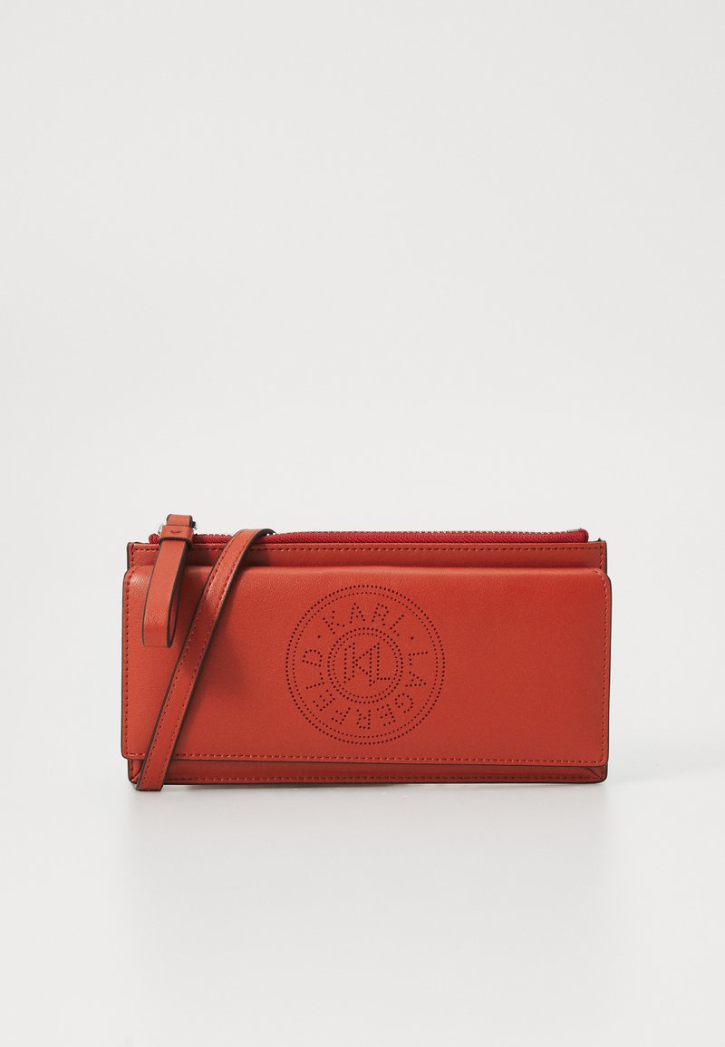Rote Leder-Clutch mit abnehmbarem Trageriemen, ausgestattet mit geprägtem Logo-Rundmotiv und einem Reißverschluss oben. Glatte Textur.