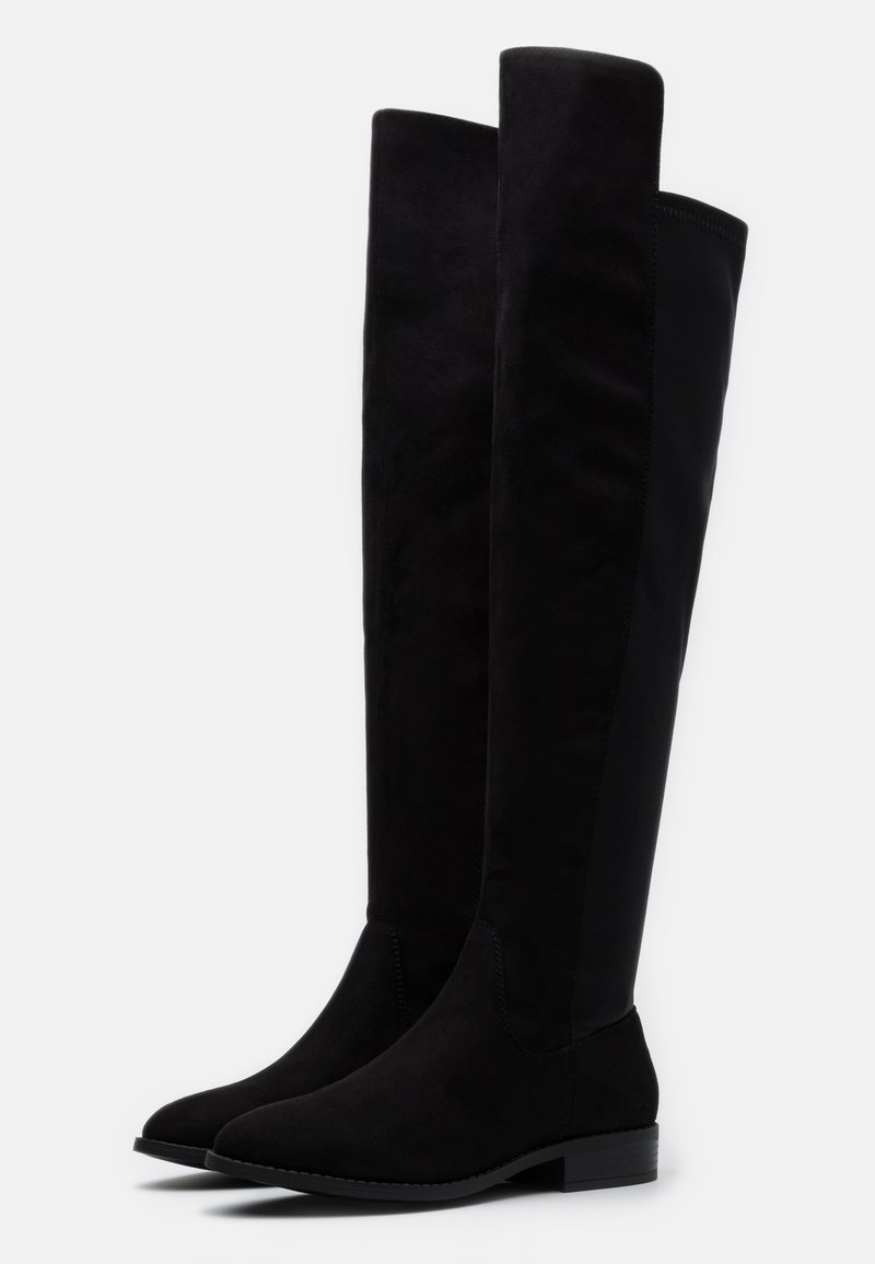 Knielange schwarze Stiefel aus samtigem Material mit glatter Oberfläche, runder Zehenpartie und niedrigem Blockabsatz für Stabilität.