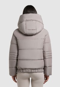 Lichtgrijze pufferjack met een grote capuchon, gestikt ontwerp, elastische taille en een gladde textuur, met horizontale stiksel details op de mouwen.