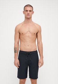Schwarze Badehosen für Herren mit Kordelzug, flacher Vorderseite, knielangem Schnitt und einfarbigem Design ohne Muster oder Akzente.