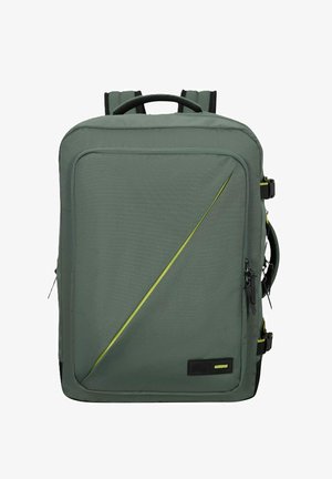 Mochila de tela verde con superficie texturizada, acento amarillo diagonal, correas de hombro acolchadas y un asa superior para llevar.