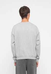 Gray crewneck sweatshirt made of soft fabric, featuring ribbed cuffs and hem, with a relaxed fit and no visible patterns or logos.