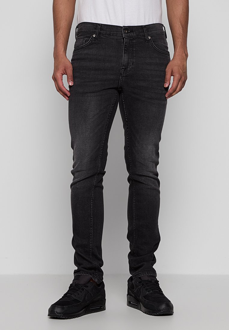 Czarne dżinsy o wąskim kroju, z klasycznym pięciopunktowym wzorem, z przeszyciami oraz delikatnym przetarciem na nogawkach.