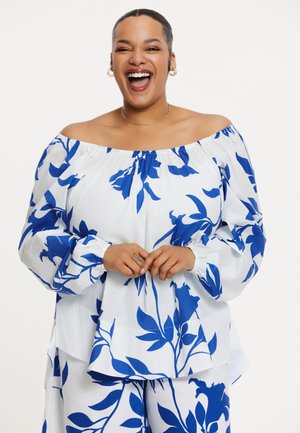 Witte off-the-shoulder blouse met een blauw bloemenpatroon, met lange mouwen en gathered manchetten. Lichtgewicht stof met een relaxte pasvorm.