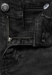 Jeans in denim nero con zip, chiusura a bottone metallico e texture usurata con dettagli di cucitura visibili.