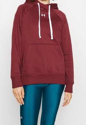 Burgunderfarbener Kapuzenpullover aus weichem Stoff mit weißer Kordel, Fronttasche und gerippten Bündchen, getragen über türkisfarbenen Leggings.