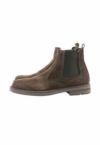 Stivali Chelsea in suede marrone con pannelli laterali elastici, punta rotonda e linguette per il tallone. Suola in gomma piatta con un discreto motivo di battistrada.