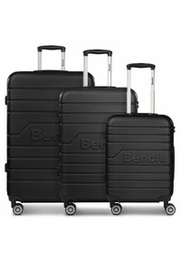 Tre valigie rigide nere di dimensioni graduati con manici telescopici argentati, strisce di accento e quattro ruote multidirezionali.