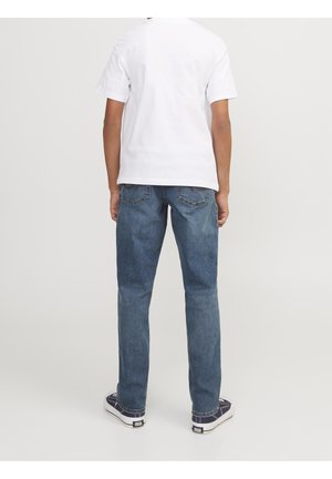 Blå denimjeans med en lige pasform, der har et klassisk design med fem lommer og synlige sømdetaljer. Kombineret med en hvid t-shirt og sneakers.