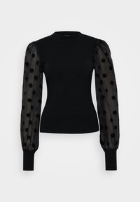 Svart tröja med figursydd ribbad bodice och transparenta puffärmar som har svarta prickar. Svarta stickade manschetter fulländar designen.