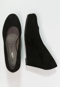 Černé semišové wedge boty s kulatou špičkou a hladkým, texturovaným povrchem. Nízký podpatek a decentní, elegantní design bez viditelných ozdob.