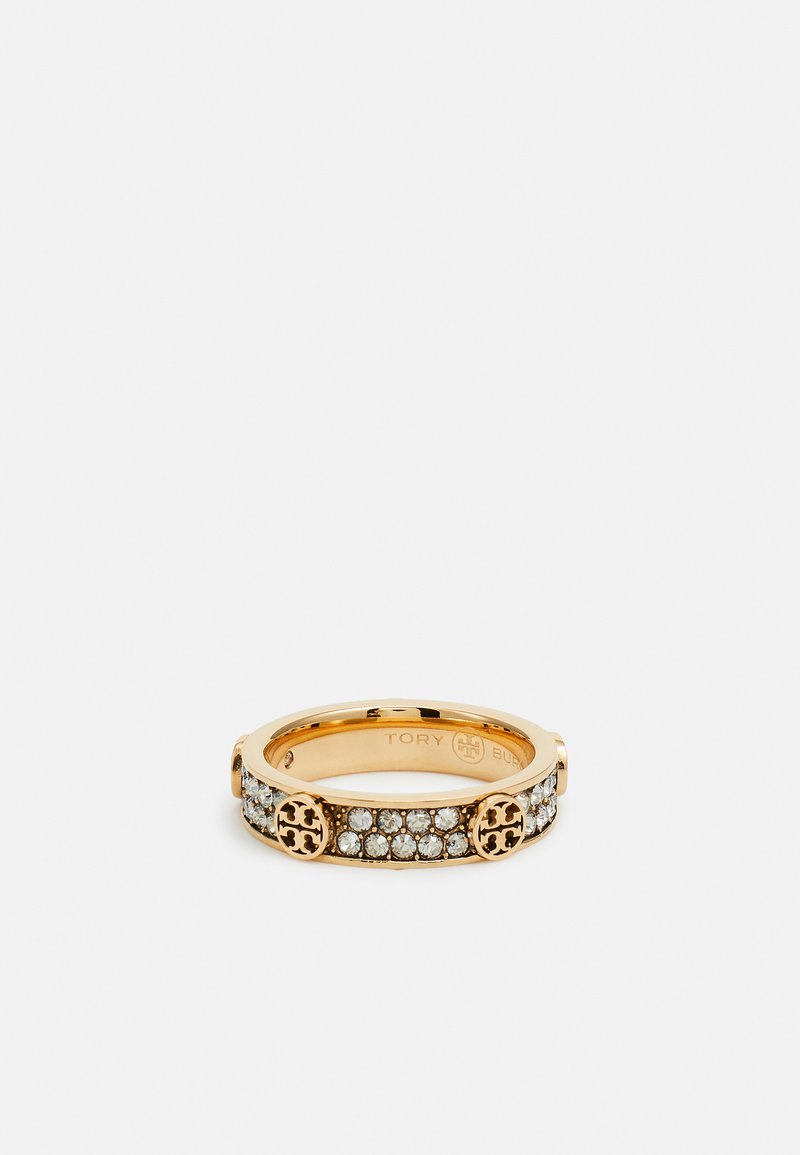 Gold-toned ring featuring a row of clear crystals and circular engraved accents on either side. Smooth finish with sleek design.