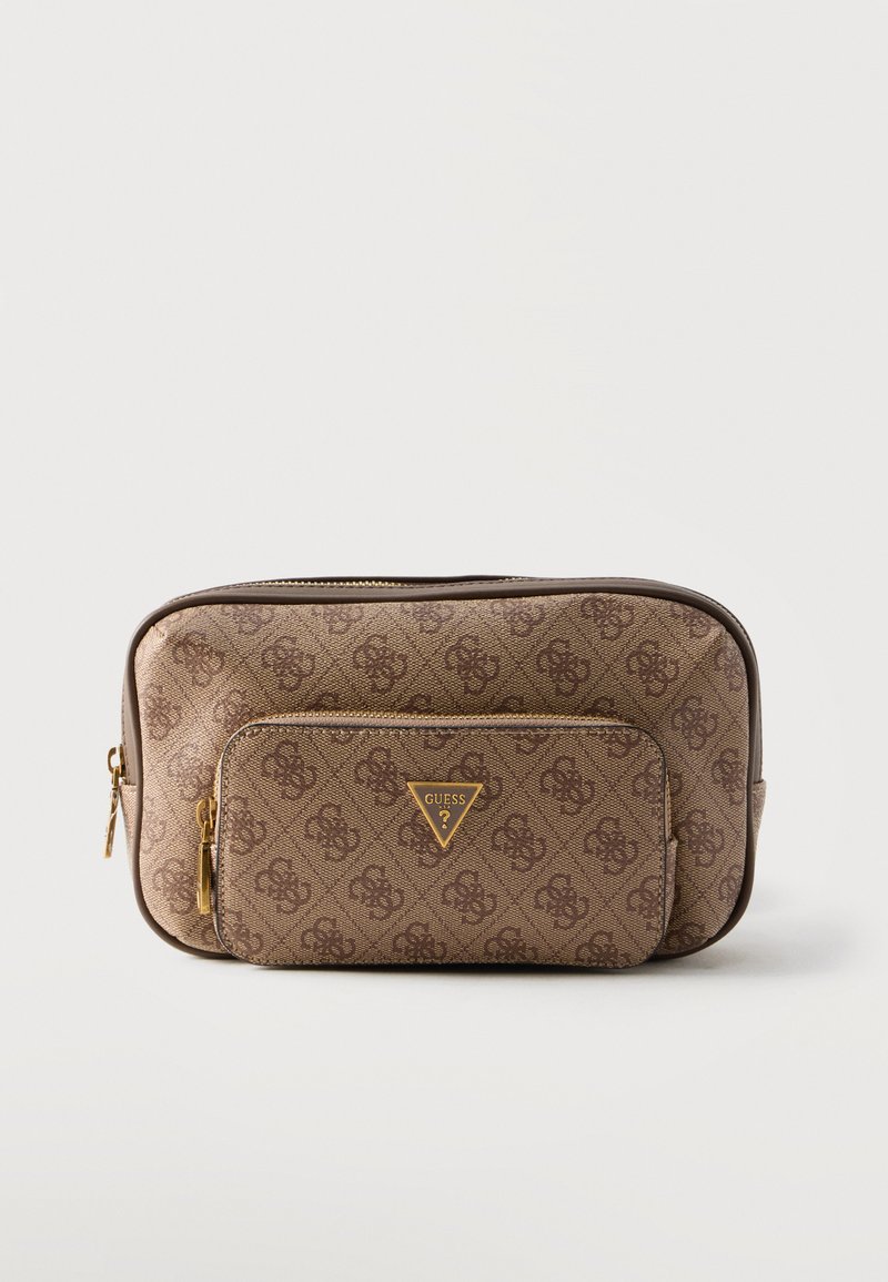 Trousse de toilette marron de créateur avec motif monogramme, poche avant zippée et logo Guess doré sur fond blanc uni.