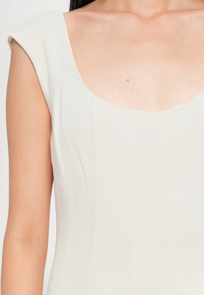 Light beige fitted dress with a square neckline, cap sleeves, and vertical seams, made from a smooth, textured fabric.