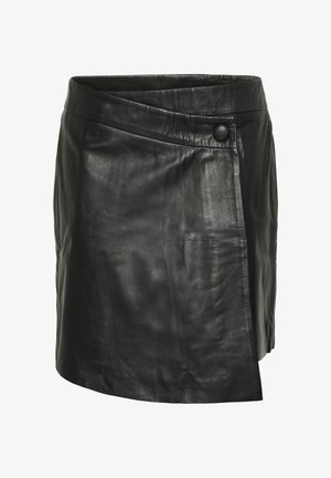 Mini-jupe en cuir noir avec devant de style portefeuille, maintenue par un seul bouton noir à la taille.