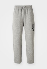 Grå sweatpants med elastisk talje, justerbar snøre og et mærke med "UA" på venstre side. Fremstillet af blødt, tekstureret stof.