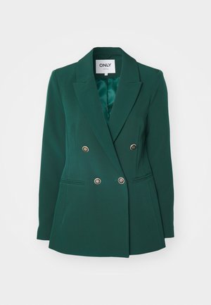 Blazer verde de doble botonadura con solapas de muesca, botones metálicos y bolsillos laterales, hecho de una tela suave con un corte ajustado.