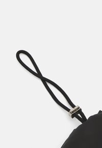 Musta, sileästä nailonista valmistettu pussukka, jossa on kiristysnyöri ja tyylikäs metalliliukusäädin turvalliseen kiinnitykseen.