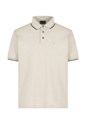 Polo de color beige claro con una superficie texturizada, tapeta de dos botones, cuello y acentos de manga en contraste oscuros, y logotipo bordado en el lado izquierdo del pecho.