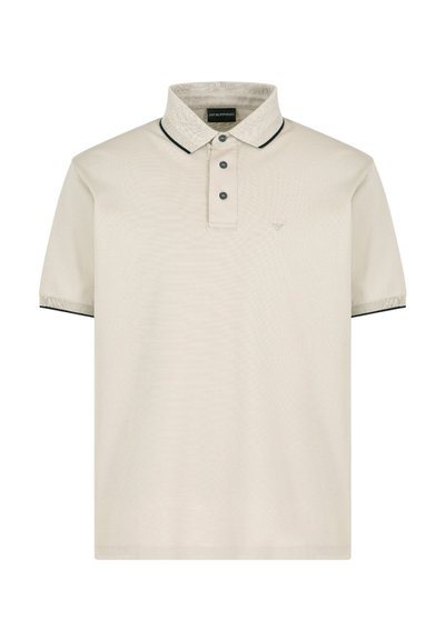 Polo de color beige claro con una superficie texturizada, tapeta de dos botones, cuello y acentos de manga en contraste oscuros, y logotipo bordado en el lado izquierdo del pecho.