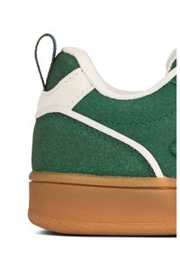 Green textile sneaker with white accents and a gum rubber sole. Features a looped heel tab and detailed stitching along the edges.