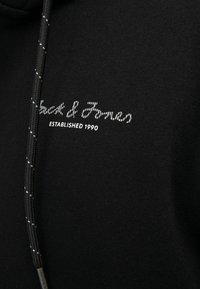 Schwarzes Sweatshirt aus strukturiertem Stoff, mit silberner Stickerei "Jack & Jones" und "Established 1990", ausgestattet mit einer Kängurutasche und einer Kapuze mit Kordelzug.