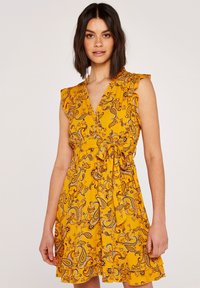Gelbes Kleid mit Paisley-Muster, Rüscheärmeln, V-Ausschnitt und Taillenknoten. Ausgestellter Rock mit geschichteter Saumdetails. Weicher Stoff.