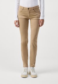 Ljust bruna, slim-fit chinos med fem fickor, framknappsstängning och slät textur. Matchas med vita sneakers.