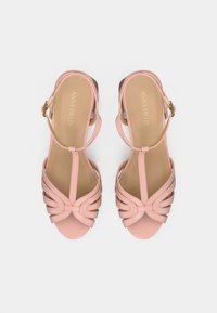 Ροζ δερμάτινα σανδάλια με σχεδίαση με λουράκια, T-bar και καμπύλη μπροστινή πλευρά με ραμμένες λεπτομέρειες. Κούμπωμα με πόρπη στον αστράγαλο. Επίπεδη σόλα.