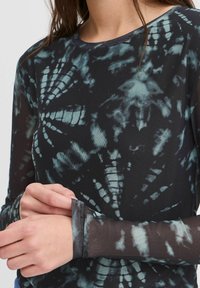 Langärmliges Oberteil mit einem schwarz und türkisfarbenen Batikmuster, aus leichtem Mesh-Stoff, mit Rundhalsausschnitt und schmalen Bündchen.