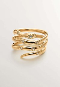 Anillo en tono dorado con un diseño ondulado que presenta cuatro bandas adornadas con pequeños acentos en forma de estrella y gemas transparentes incrustadas.