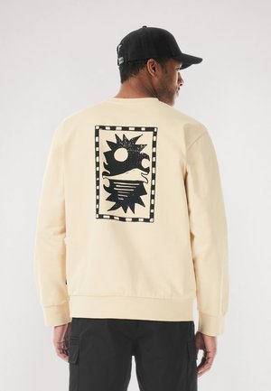 Cream-colored sweatshirt featuring a large black graphic print on the back with a sun and waves design, ribbed cuffs, and hem details.