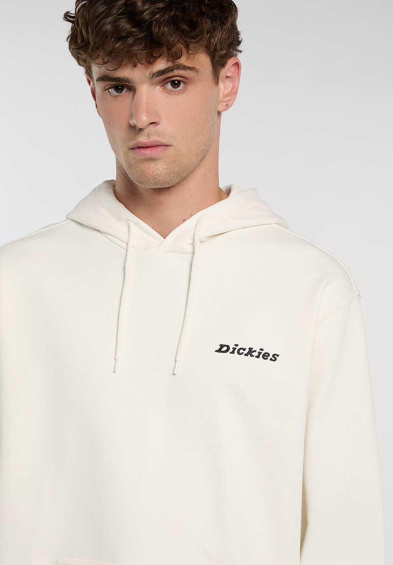 Roomkleurige hoodie gemaakt van zachte stof, met een voorzak (kangaroo pocket) en het geborduurde "Dickies"-logo in het zwart op de borst.