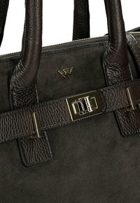 Czarna skórzana torebka z zamszu w ciemnym brązie, z teksturowanymi uchwytami, detali metalowego w kolorze złotym oraz małym metalowym logo z przodu.