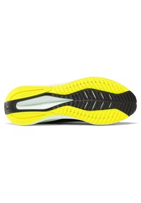 Semelle de chaussure présentant un design en caoutchouc noir et jaune, texturée pour l'adhérence, avec une semelle intermédiaire blanche et des détails en bandes pour la stabilité.