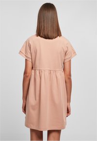 Rotes Baumwollkleid mit kurzen Ärmeln, gerafftem Taillenbereich und lockerer Passform. Glatte Textur, knielang, einfaches Design.