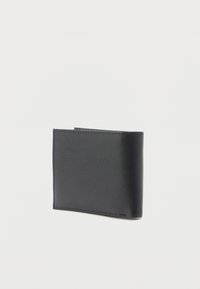 Zwarte leren bifold portemonnee met zichtbare stiksels, gesloten en staand tegen een effen witte achtergrond.