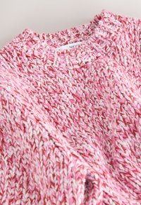 Pull épais tricoté rose, blanc et rouge avec un col ras du cou côtelé et un motif texturé.