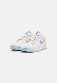 Bílé sportovní boty s fialovými akcenty, béžovými tkaničkami a tyrkysovými prvky. Vlastnosti zahrnují perforovaný špičku a gumovou podrážku s podpůrnými detaily.