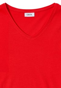 T-shirt rossa a maniche corte con scollo a V, realizzata in tessuto morbido. Presenta un'etichetta con "CECIL" sul colletto. Texture semplice e uniforme.