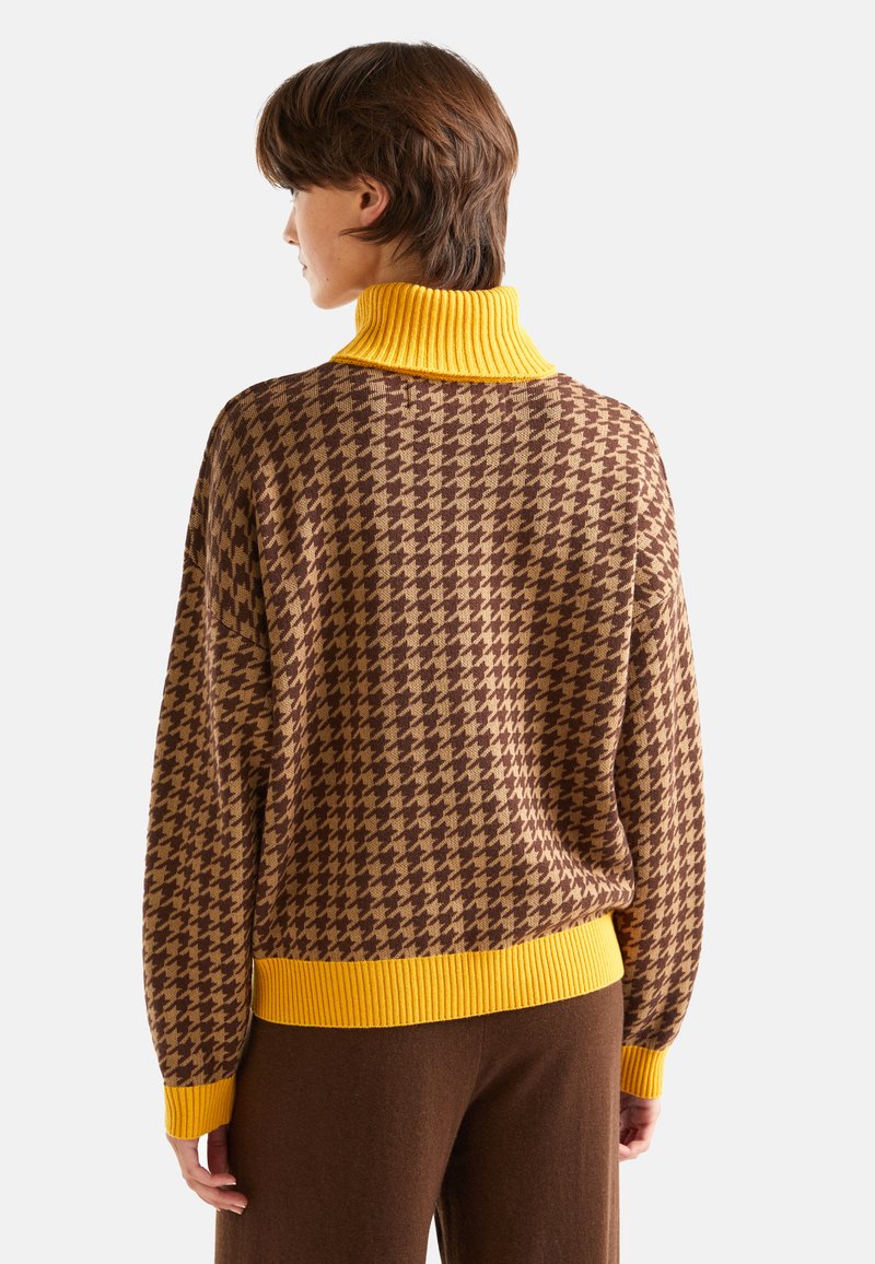 Sweter w wzór houndstooth w odcieniach brązu i beżu, z żółtym prążkowanym golfem i mankietami. Miękka faktura i luźny krój.