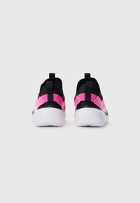 Une paire de chaussures de sport noires et roses avec des semelles blanches, vue de l'arrière sur un fond gris clair uni.