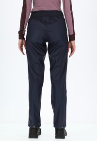 Wasserdichte marineblaue Hosen mit elastischem Bund und Druckknopfverschlüssen am Knöchel, die für Komfort und Bewegungsfreiheit ausgelegt sind.