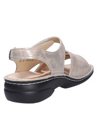 Sandale beige à bout ouvert avec finition métallisée, bride cheville réglable, semelle intérieure rembourrée et semelle extérieure épaisse noire profilée pour le confort.