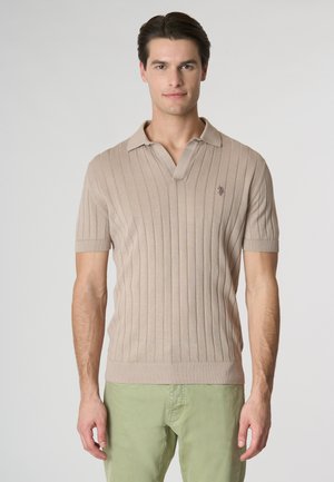 Polo shirt a coste beige con maniche corte, caratterizzato da un colletto e un sottile dettaglio del logo sul petto. Tessuto in maglia morbida e design testurizzato.