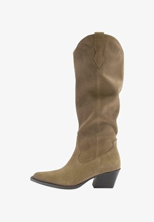 Visoka rjava kavbojska škornja iz semiša z ostrim prstom, srednje visoko naloženim petom in zanke na vrhu, prikazana od strani.