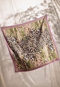 Foulard en soie à motif léopard dans des nuances de vert, marron et rose, bordé d'une garniture accentuée rose clair et verte.
