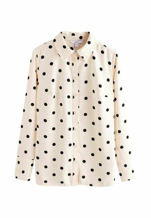 Cremefarbene Langarm-Bluse mit Knopfleiste, schwarzen Polka-Dots und spitzem Kragen, vor weißem Hintergrund präsentiert.